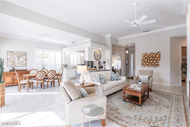 living area with a ceiling fan, ornamental molding, a healthy amount of sunlight, and light tile patterned floors