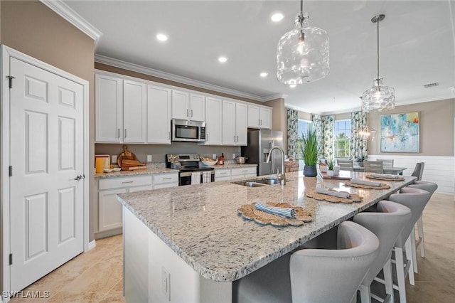 14600 Sycamore Ct Unit 2022, Punta Gorda, FL 33955 - kitchen featuring appliances with stainless steel finishes, a sink, ornamental molding, a spacious island, and white cabinetry