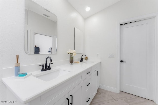 12484 SW Sheri Ave, Lake Suzy, FL 34269 - bathroom featuring double vanity, baseboards, and recessed lighting
