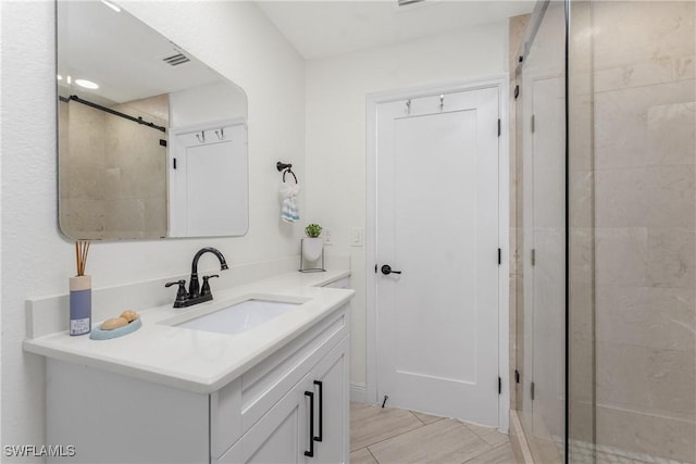 full bath with a shower, wood tiled floor, vanity, and visible vents