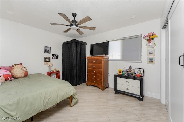 bedroom with a ceiling fan and baseboards