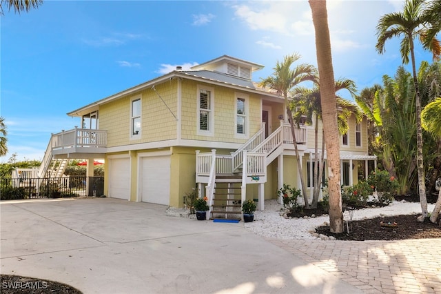 5773 Sanibel Captiva Rd, Sanibel, FL 33957 - view of front of property featuring driveway, stucco siding, an attached garage, fence, and stairway