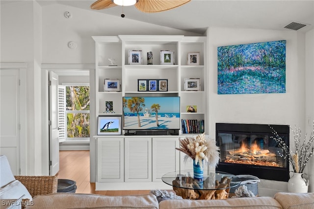 5773 Sanibel Captiva Rd, Sanibel, FL 33957 - living area with lofted ceiling, visible vents, ceiling fan, a glass covered fireplace, and wood finished floors