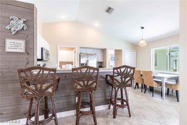 3801 SW 1st Ln, Cape Coral, FL 33991 - kitchen featuring a kitchen breakfast bar, decorative light fixtures, visible vents, vaulted ceiling, and stainless steel appliances