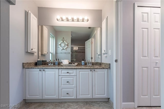 3801 SW 1st Ln, Cape Coral, FL 33991 - full bathroom featuring a closet, double vanity, baseboards, a sink, and a stall shower