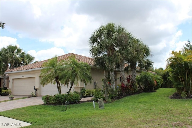14768 Cranberry Ct, Naples, FL 34114 - exterior space featuring a front yard, an attached garage, a tile roof, stucco siding, and decorative driveway
