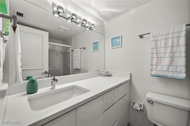full bath featuring toilet, vanity, visible vents, and a stall shower