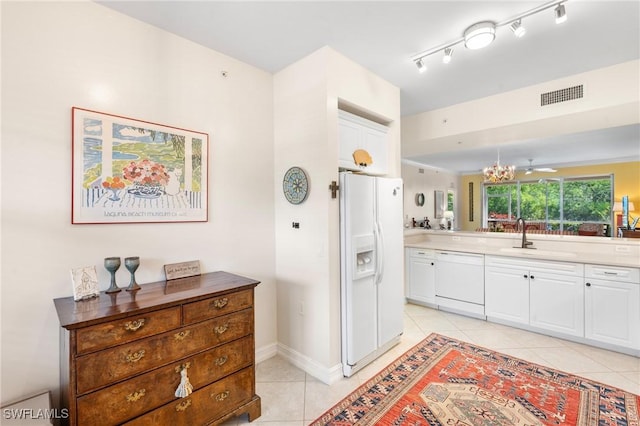10520 Amiata Way Unit 104, Fort Myers, FL 33913 - kitchen featuring white appliances, light tile patterned floors, white cabinetry, and a chandelier