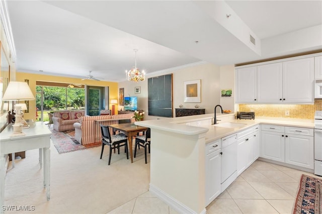 10520 Amiata Way Unit 104, Fort Myers, FL 33913 - kitchen with white appliances, open floor plan, a peninsula, white cabinetry, and crown molding