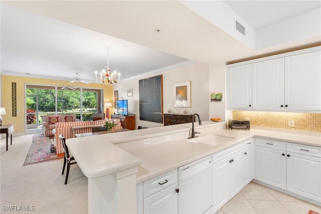 10520 Amiata Way Unit 104, Fort Myers, FL 33913 - kitchen with dishwasher, a peninsula, backsplash, white cabinetry, and crown molding