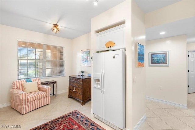 10520 Amiata Way Unit 104, Fort Myers, FL 33913 - kitchen featuring white fridge with ice dispenser, light tile patterned floors, and white cabinetry