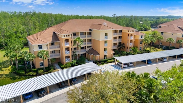 10520 Amiata Way Unit 104, Fort Myers, FL 33913 - view of apartment building / complex with covered parking and a wooded view