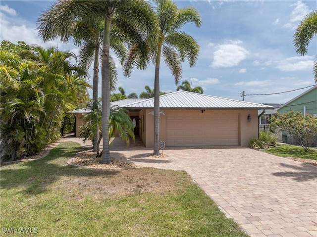 2020 Aruba Ave, Fort Myers, FL 33905 - single story home with a garage, stucco siding, a front lawn, driveway, and metal roof