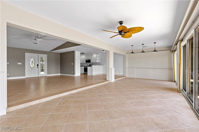 2020 Aruba Ave, Fort Myers, FL 33905 - unfurnished living room featuring a ceiling fan, light tile patterned floors, baseboards, and vaulted ceiling