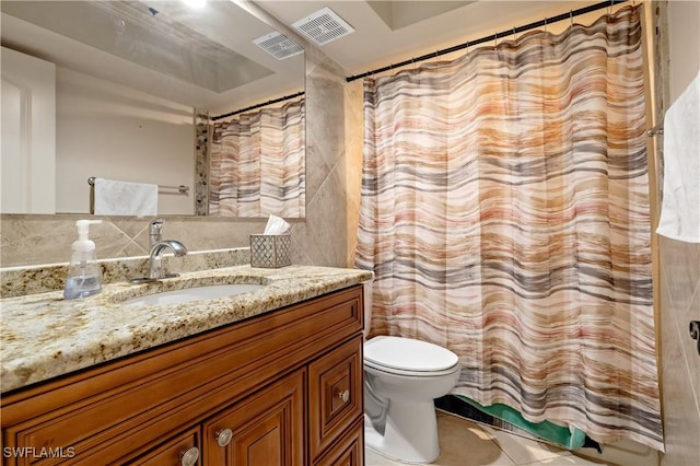 2020 Aruba Ave, Fort Myers, FL 33905 - bathroom with toilet, vanity, tile patterned flooring, and tile walls