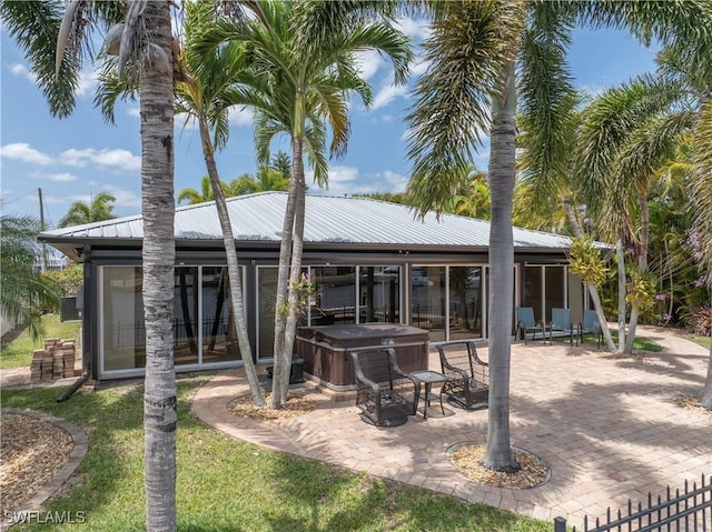 2020 Aruba Ave, Fort Myers, FL 33905 - back of property with a hot tub, a sunroom, a patio, and metal roof
