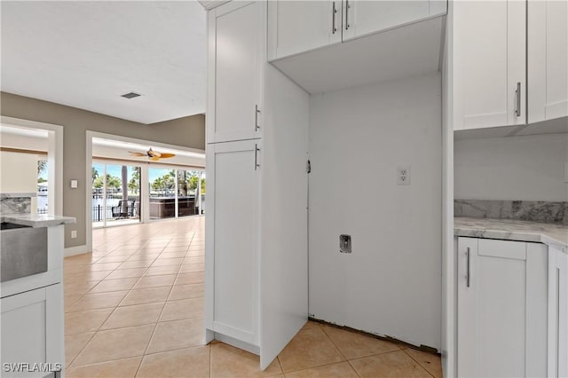 2020 Aruba Ave, Fort Myers, FL 33905 - kitchen with light tile patterned floors, ceiling fan, white cabinets, a water view, and light stone counters