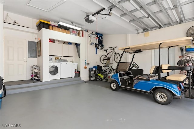 garage featuring washing machine and dryer, a garage door opener, and electric panel
