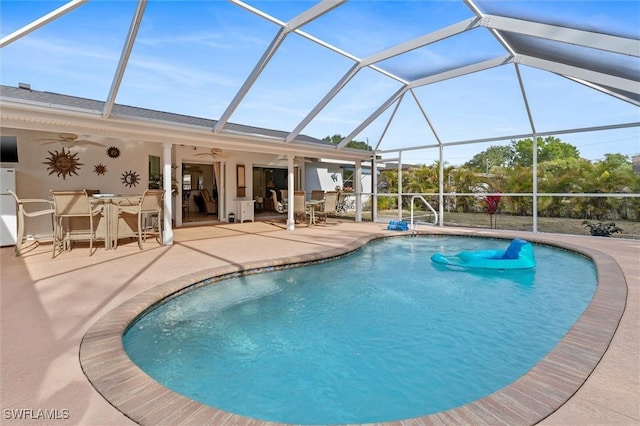 outdoor pool featuring glass enclosure, outdoor dining space, ceiling fan, and a patio area