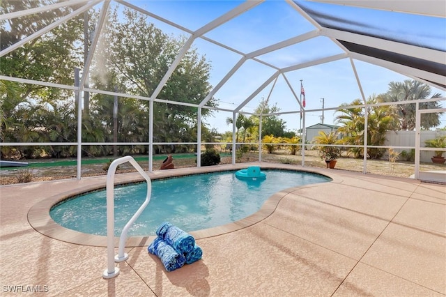 outdoor pool with fence, a lanai, and a patio area