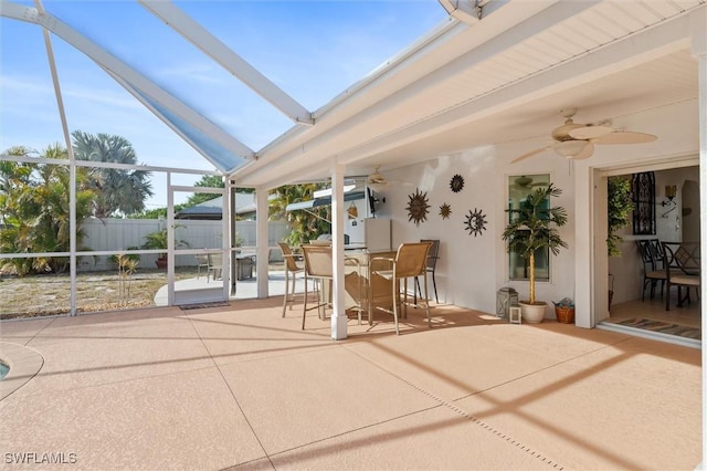 unfurnished sunroom with outdoor dining space and a ceiling fan