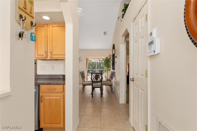 hallway with visible vents and light tile patterned floors