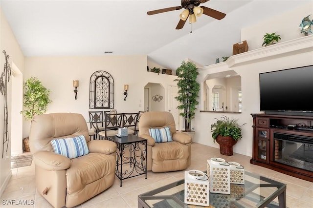 living room featuring vaulted ceiling, light tile patterned floors, arched walkways, visible vents, and a ceiling fan