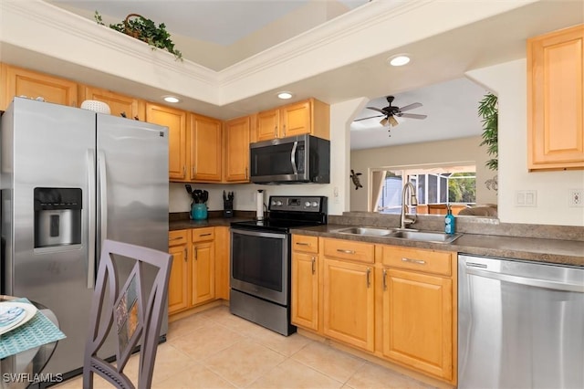 kitchen with a sink, a ceiling fan, stainless steel appliances, dark countertops, and recessed lighting