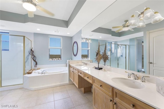 bathroom featuring a bath, a tray ceiling, a sink, and a ceiling fan