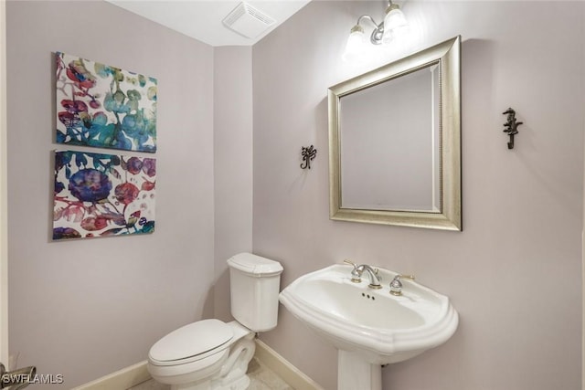 bathroom featuring baseboards, visible vents, toilet, and a sink