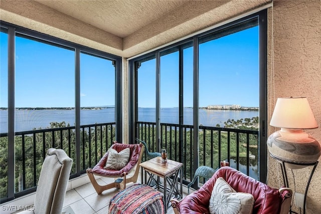 sunroom / solarium with tile patterned flooring, a water view, and a wealth of natural light