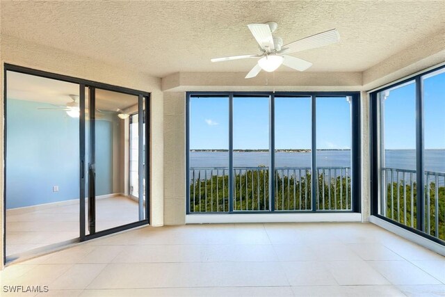 11600 Court Of Palms Unit 506, Fort Myers, FL 33908 - unfurnished sunroom featuring a water view, a textured ceiling, and tile patterned floors
