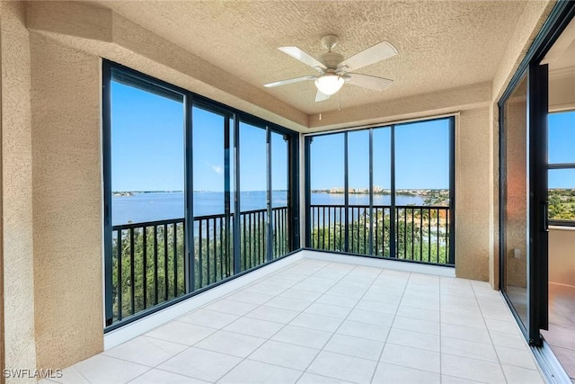 11600 Court Of Palms Unit 506, Fort Myers, FL 33908 - unfurnished sunroom featuring a water view, a textured wall, a textured ceiling, and tile patterned floors