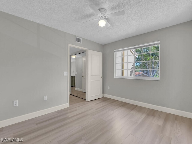 1180 Wildwood Lakes Blvd Unit 207, Naples, FL 34104 - unfurnished bedroom with visible vents, baseboards, wood finished floors, and a textured ceiling