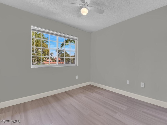 1180 Wildwood Lakes Blvd Unit 207, Naples, FL 34104 - empty room featuring a textured ceiling, baseboards, a ceiling fan, and wood finished floors