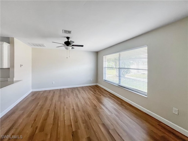 unfurnished living room with visible vents, ceiling fan, and baseboards