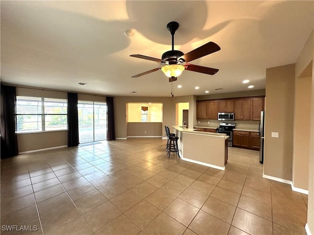 8091 Allamanda Ct, Lehigh Acres, FL 33972 - kitchen featuring open floor plan, ceiling fan, light tile patterned floors, and stainless steel appliances