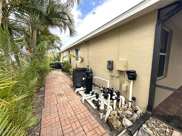 8091 Allamanda Ct, Lehigh Acres, FL 33972 - view of side of home with stucco siding and a patio