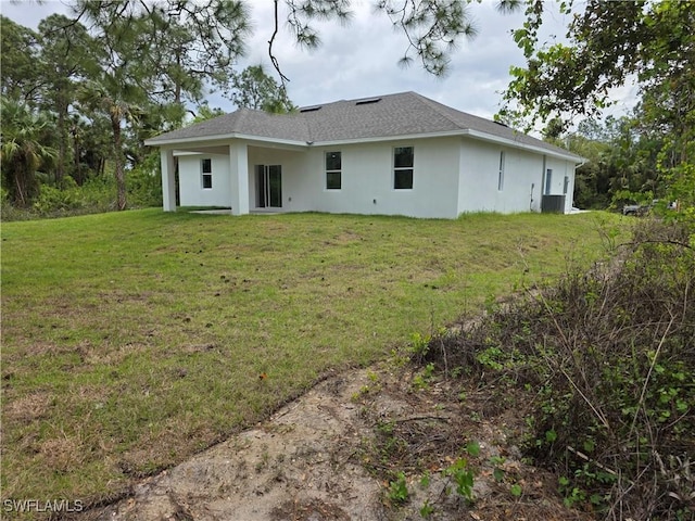 back of property featuring stucco siding and a lawn