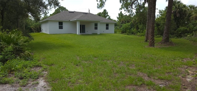 5005 Eifel Ln, Labelle, FL 33935 - back of property with stucco siding, a lawn, and a shingled roof