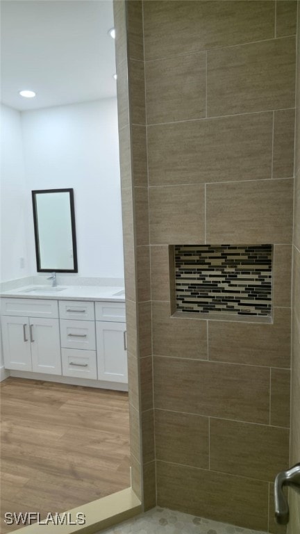 5005 Eifel Ln, Labelle, FL 33935 - bathroom featuring double vanity, a tile shower, wood finished floors, and recessed lighting
