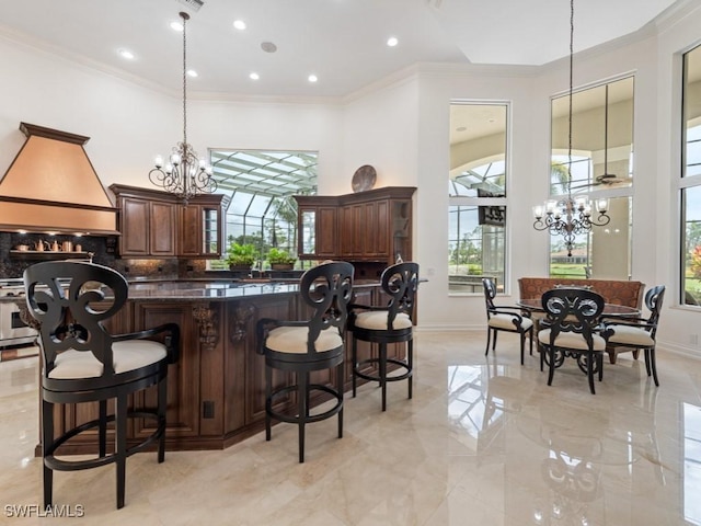 4244 Brynwood Dr, Naples, FL 34119 - kitchen featuring ornamental molding, a notable chandelier, a healthy amount of sunlight, and custom exhaust hood