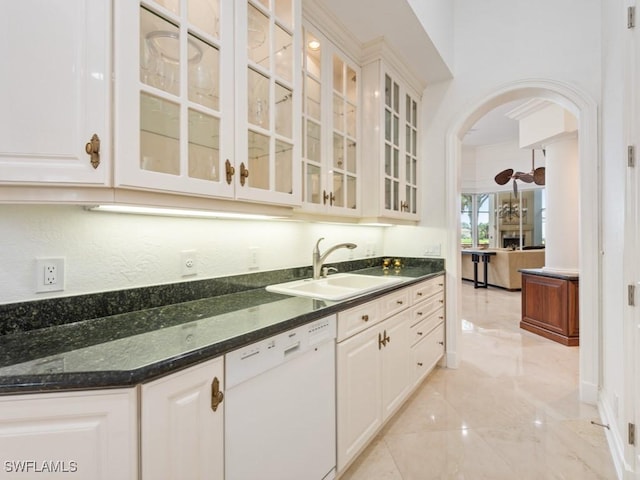4244 Brynwood Dr, Naples, FL 34119 - kitchen with dark stone counters, a sink, arched walkways, dishwasher, and glass insert cabinets