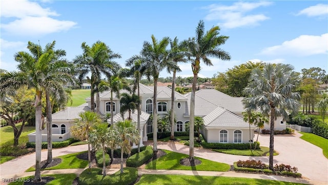 4244 Brynwood Dr, Naples, FL 34119 - mediterranean / spanish-style home with a tile roof, a front yard, curved driveway, and stucco siding