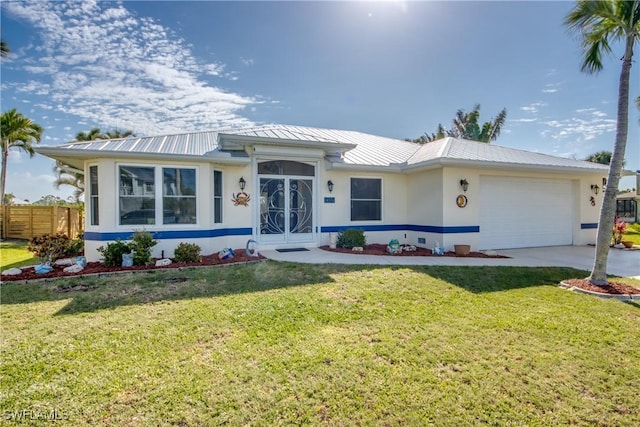 view of front facade with stucco siding, metal roof, and a front yard