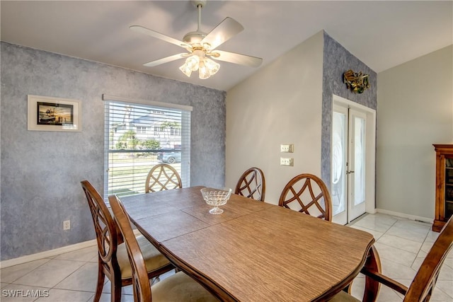 dining space featuring a ceiling fan, light tile patterned floors, and baseboards