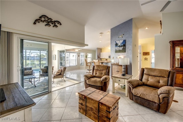 living area with light tile patterned flooring, lofted ceiling, and ceiling fan