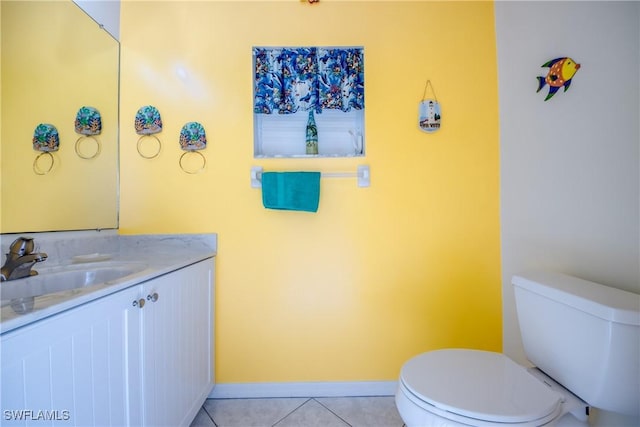 bathroom featuring baseboards, toilet, tile patterned flooring, and vanity