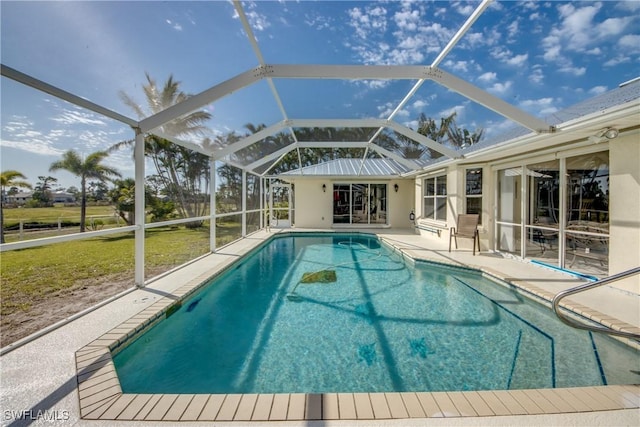 outdoor pool featuring glass enclosure and a patio