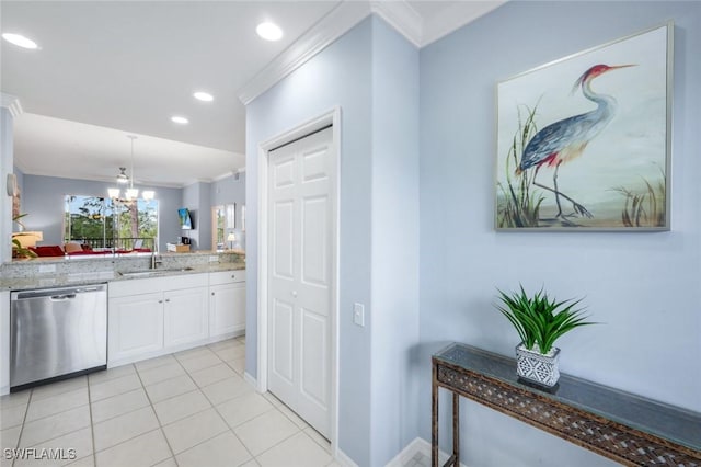 kitchen with crown molding, a sink, white cabinetry, stainless steel dishwasher, and hanging light fixtures